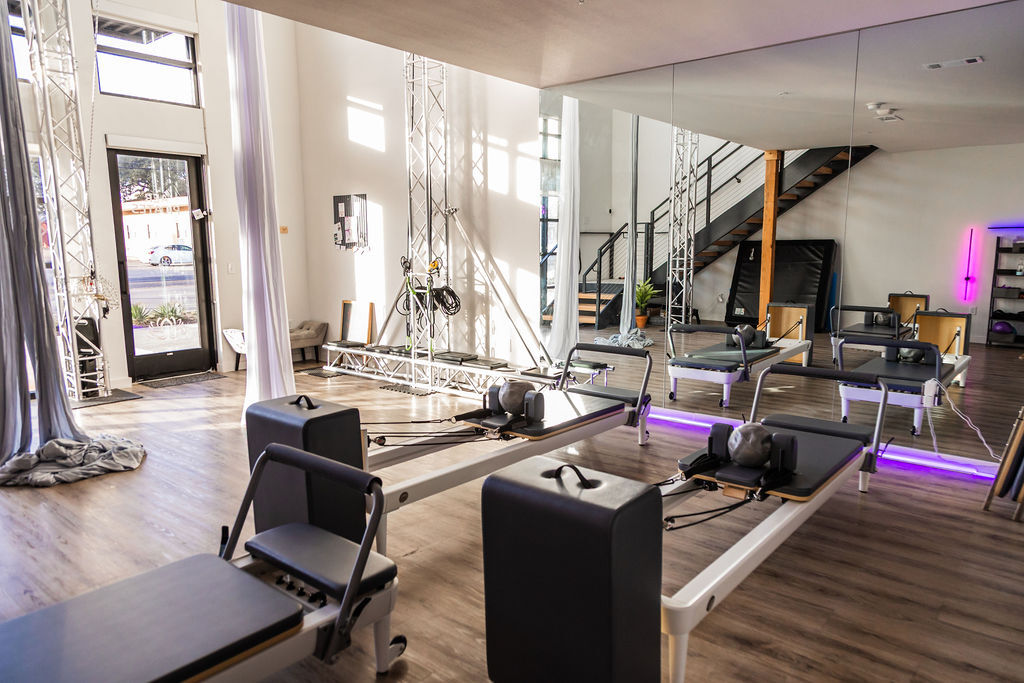 The Aer Pilates studio floor — Reformers and aerial silks rigging in the St. Elmo District of South Austin